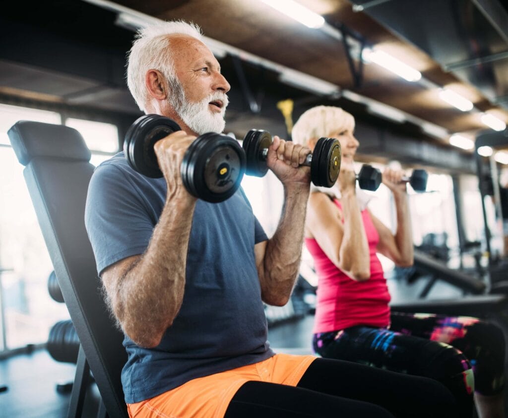 Glückliche ältere Menschen machen Übungen im Fitnessstudio, um fit zu bleiben