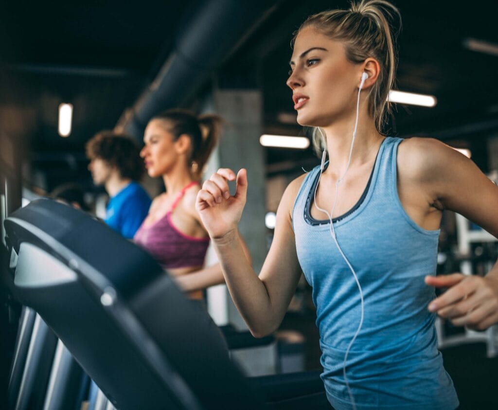 Junge Leute laufen auf einem Laufband im Fitnessstudio.